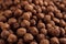 Chocolate balls corn flakes closeup background. Cereals texture.