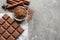 Chocolate bar and cocoa powder on grey background