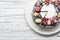 chocolate berry cake on plate over white wooden background