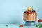 Chocolate birthday cake with berries, cookies and number fifty golden candles on blue wall background, copy space