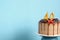 Chocolate birthday cake with berries, cookies and number forty golden candles on blue wall background, copy space