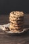 Chocolate biscuits on wooden base with black background, vertical format. Sweet food concept