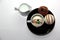 Chocolate bombs in mug with hot milk, filled with marshmallows and white chocolate on white background