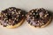 chocolate brownie donuts on table. The donuts is brown glazed with brownie parts