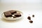 Chocolate brownie sliced into square slices on a white plate