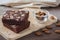 Chocolate brownie topping with almond slices on wooden plate