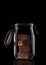 Chocolate Brownies in a glass storage or canning jar isolated on black with reflection, with lid open