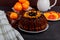 Chocolate bundt cake with chocolate ganache and orange on wooden cutting board. Closeup view