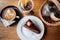 Chocolate cake, cappucino, peach tea and seasoning on a wood background