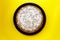 Chocolate cake decorated with flaked coconut, homemade pie on yellow background, top view. Home cake with cocoa ingredient on