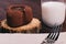 Chocolate cake and glass of milk on a brown table, fork on the t