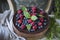 Chocolate cake with mascarpone on rustic background with raspberries, blueberries and mint leaves.