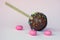 Chocolate cake pops with coconut flakes on a pink background. Mini cakes on a wooden stick. A popular sweet dessert