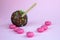 Chocolate cake pops with coconut flakes on a pink background. Mini cakes on a wooden stick. A popular sweet dessert