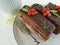 chocolate cake, red currant, mint, flower plate on white wooden