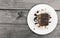 Chocolate cake slice with nut on plate on wooden table, top view