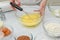 Chocolate cake step by step recipe. Woman whisks egg yolks with sugar in a glass bowl