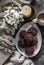 Chocolate cakes with almonds, coffee, knitted plaid, book, bouquet of chrysanthemums, candle on a dark background, top view