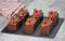 Chocolate cakes with decorated ganache and raspberries on a black cake stand