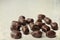 Chocolate candies. Dark chocolates with natural plum filling. Old paper textured image