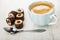 Chocolate candies, spoon, espresso in blue cup on wooden table