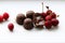 Chocolate candies with starchy corn syrup and condensed milk on a white plate with ripe, puff, juicy sweet cherry berries