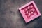 Chocolate candy heart in a pink box on a dark rustic surface. Valentine`s Day, a festive background. View from above