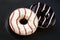 Chocolate and caramel glazed donuts on dark minimal background, top view