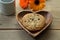 Chocolate chip cookie on the heart-shaped wooden plate with transvaal daisies