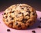 a chocolate chip cookie on a pink plate