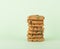 Chocolate chip cookies on green background, reflective surface, piled cookies.