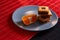 Chocolate chip cookies and piece of orange on plate and on red and black background with place for text selective focus with copys