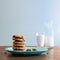 Chocolate chip cookies stacked on a plate with milk