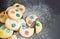 Chocolate chips and multicolored candy homemade shortbread cookies icing powdered on gray background. Selective focus.