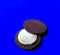 Chocolate cookie filled with cream on blue background. desserts concept