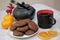 Chocolate cookies and black tea utensils. Cup and teapot. Dried orange slices. Tea scene