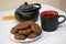 Chocolate cookies and black tea utensils. Cup and teapot. Dried orange slices. Tea scene