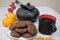 Chocolate cookies and black tea utensils. Cup and teapot. Dried orange slices. Tea scene