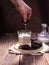 Chocolate cookies, glass with milk on a brown background, hand holding a cookie