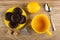 Chocolate cookies in saucer, lemon, sugar cubes, tea bag, cup, spoon on wooden table. Top view