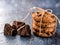 Chocolate cookies, stacked and tied with a rope, pieces of black chocolate, on a textured background