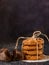 Chocolate cookies, stacked and tied with a rope, pieces of black chocolate, on a textured background. Close-up