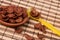 Chocolate corn flakes in clay disk and yellow plastic spoon