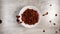 Chocolate cornflakes splash into white dish in slow motion