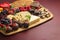 A Chocolate Covered Strawberries and Cheese Sweet Charcuterie Board on a Red Table