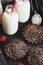 Chocolate cream cake and milk in a bottle on a black wooden tray. Selective focus. Tasty breakfast