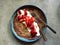 Chocolate crepe on plate with nut butter, cream, fresh strawberries