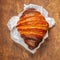 Chocolate croissant on wooden table top view. Freshly backed croissants for breakfast