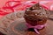 Chocolate cupcake with chocolate cream, decorated with ribbon, on a brown plate with the inscription love .