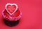 Chocolate cupcake with Valentines heart on the top, over red